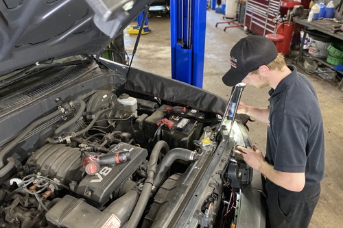A mechanic peformes factory recommended maintenance on an SUV at Collinsville Auto