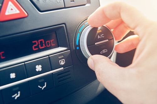 Get Ready for the Heat with A/C Service and Repair with Collinsville Auto in Canton, Ct. image of hand turning up the ac dial in vehicle dashboard