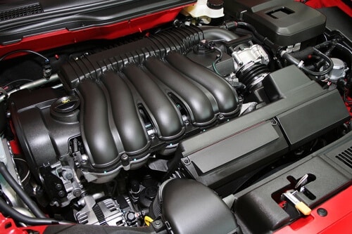 Why Get Fuel and Air Induction Cleaning Services in Canton, CT with Collinsville Auto, closeup image of intake manifold system of red car in shop