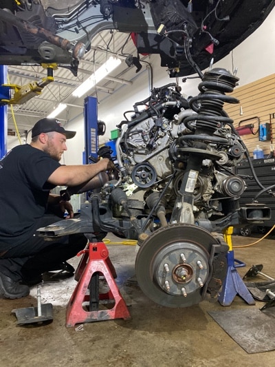 auto repair technician at Collinsville Auto Repair in Canton CT, working on big truck suspension system