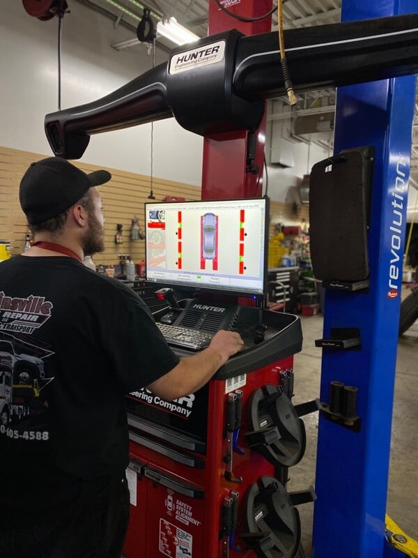 Collinsville Auto Repair technician operating hunter alignment machine in shop 