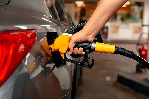 Car Maintenance Tips for Better Fuel Economy | Collinsville Auto in Canton, CT. Closeup image of a man's hand filling a gas tank. Concept image of rising fuel prices and fuel economy.