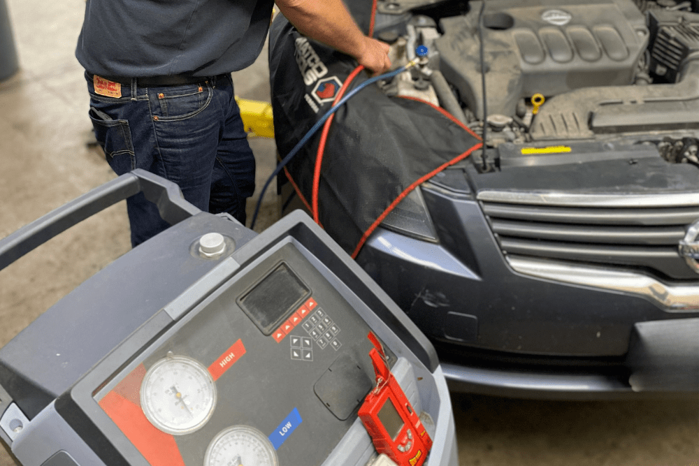 Auto A/C Repair in Canton, CT by Collinsville Auto Repair. Technician uses a Robinair machine to service a car's air conditioning system, ensuring reliable cooling during the summer heat.