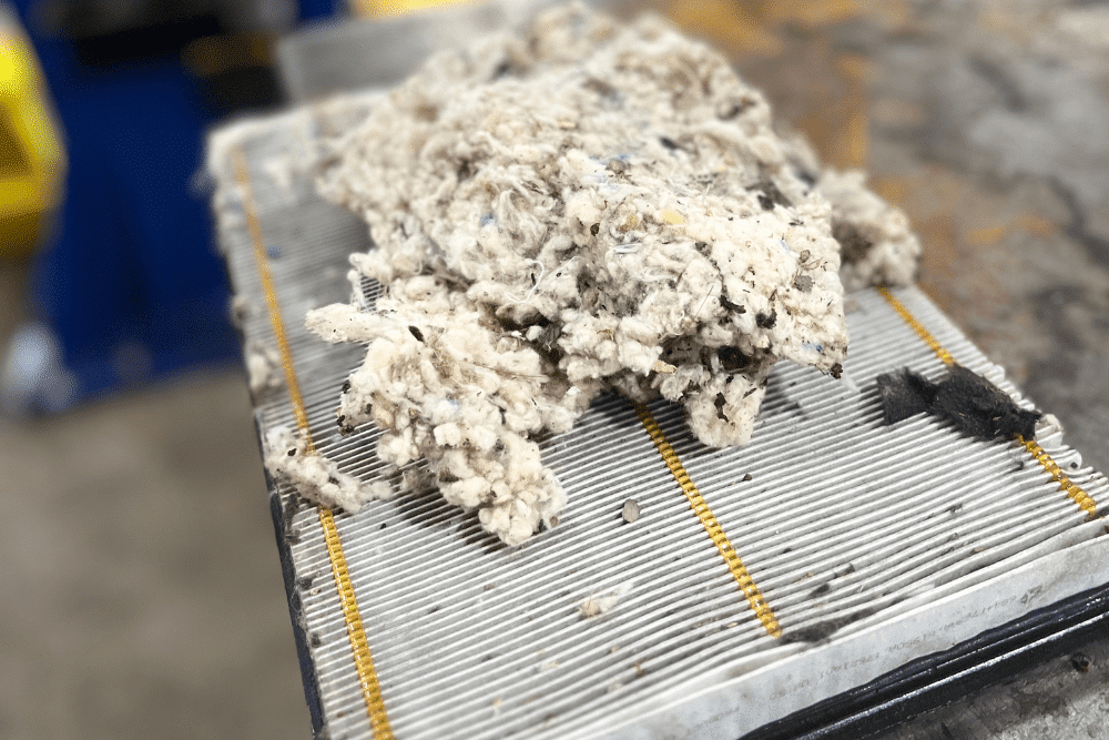 Cabin air filter replacement in Canton, CT by Collinsville Auto Repair. Image showing a heavily contaminated air filter filled with debris and lint buildup, stressing the importance of routine cabin filter replacement for clean air and proper HVAC function.