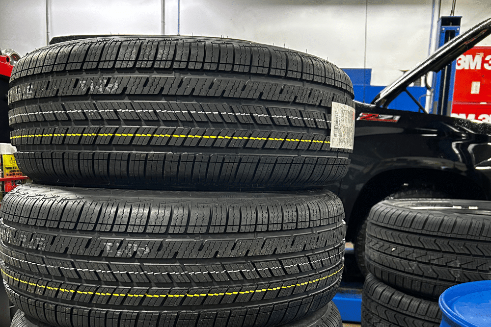 Snow tires, auto repair in Canton, CT by Collinsville Auto Repair. Image of stacked new tires in a repair shop. Highlighting Collinsville Auto Repair’s commitment to providing quality tire services and ensuring vehicle safety.