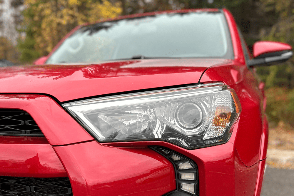 Winter travel, auto repair in Canton, CT by Collinsville Auto Repair. Image of a bright red SUV showcasing a clear, well-maintained headlight, emphasizing visibility and safety.